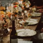 a table with wine glasses and flowers