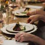 a group of people sitting at a table with plates of food. Private chef Dinner